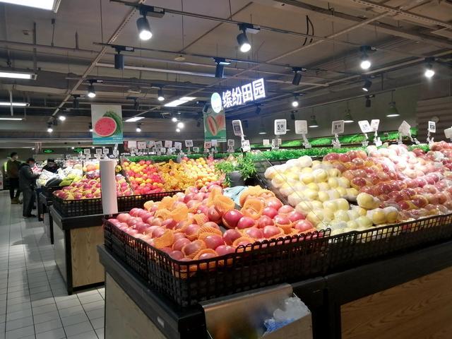 石景山区物美超市八角西街店蔬菜果品保障充足,居民在超市内选购商品.
